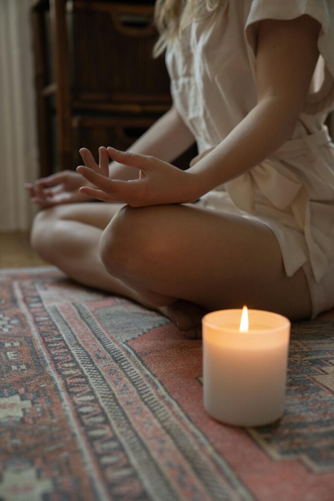 pexels-photo-9032690-9032690 Experience tranquility with a lit candle and meditative pose, ideal for mindfulness practices.
